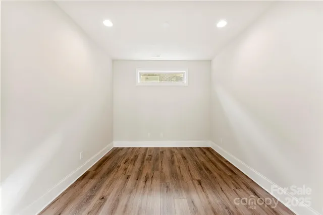 a view of room with wooden floor and white walls