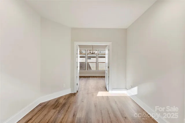 a view of a room with wooden floor and a window