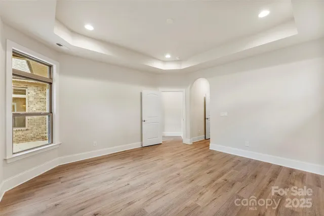 an empty room with wooden floor and window