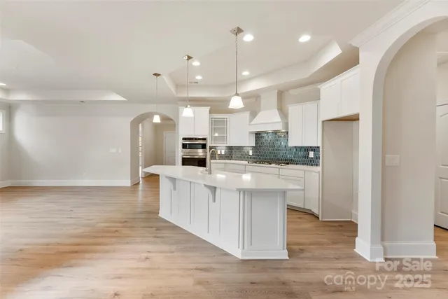 a large kitchen with kitchen island a sink stainless steel appliances and cabinets
