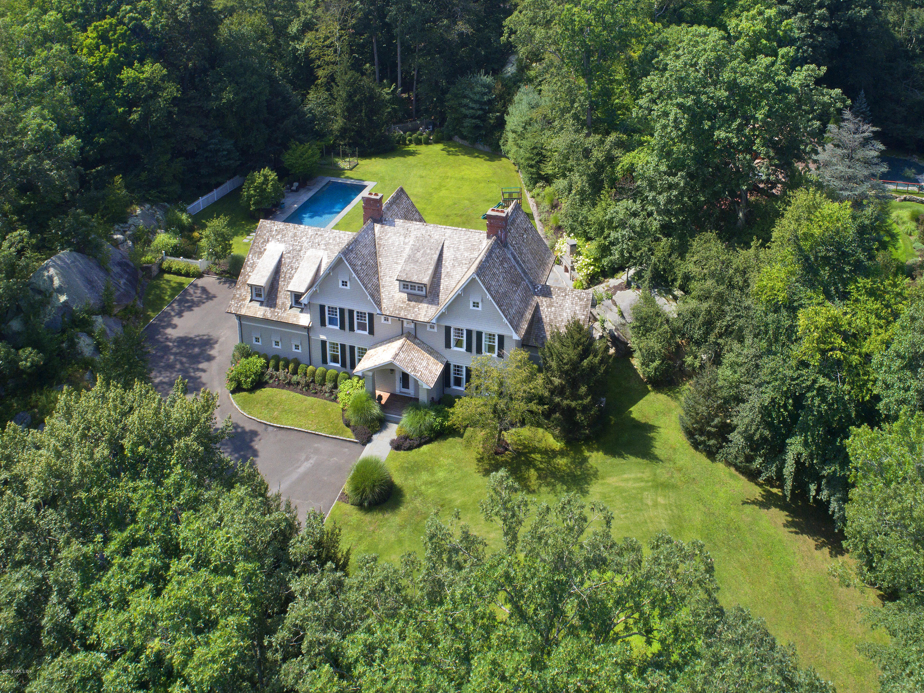 an aerial view of a house with a garden and swimming pool