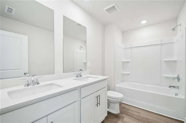 a bathroom with a granite countertop sink a toilet and a bathtub