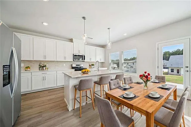 a kitchen with white cabinets and stainless steel appliances