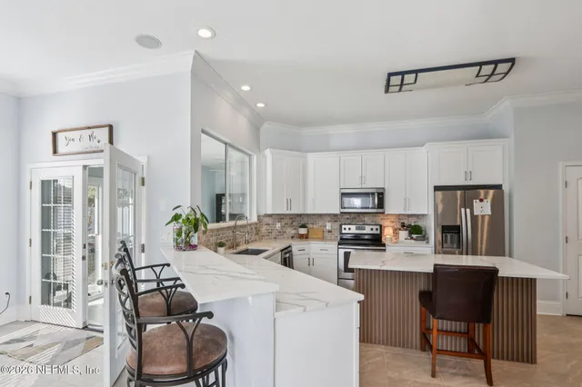a kitchen with stainless steel appliances a stove refrigerator sink and microwave