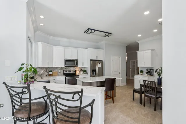 a dining room with furniture and kitchen view