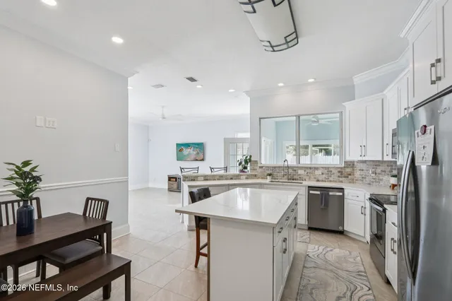 a kitchen with refrigerator and chairs