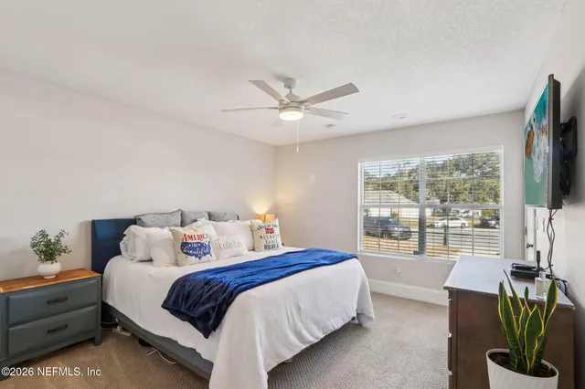 a bedroom with a large bed and a chandelier