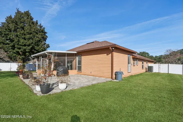 a backyard of a house with table and chairs a barbeque with wooden fence