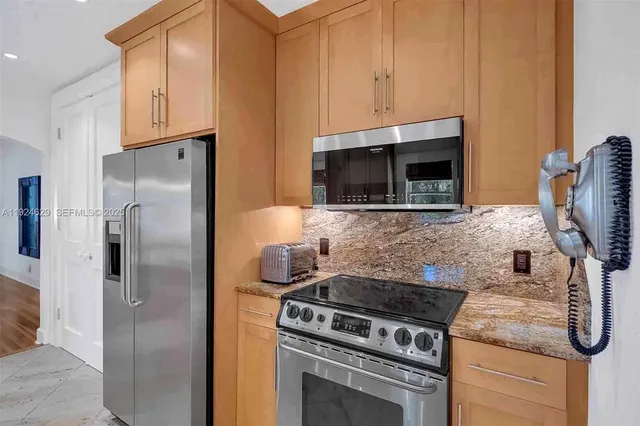 a kitchen with stainless steel appliances granite countertop a stove a refrigerator and a microwave