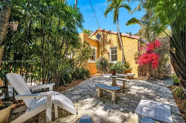 a backyard of a house with table and chairs