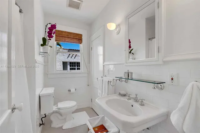 a bathroom with a sink mirror and toilet