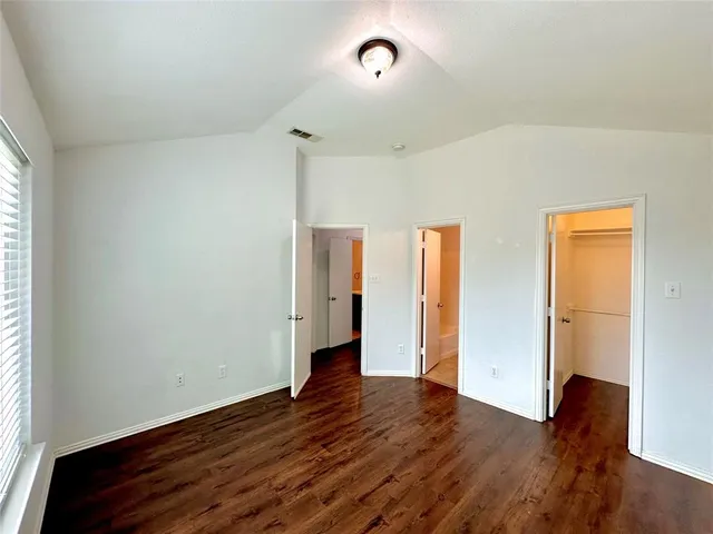 a view of an empty room with wooden floor