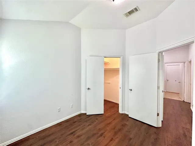 an empty room with wooden floor and entrance