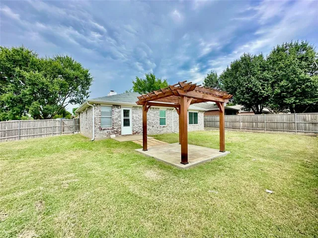 a backyard of a house with table and chairs