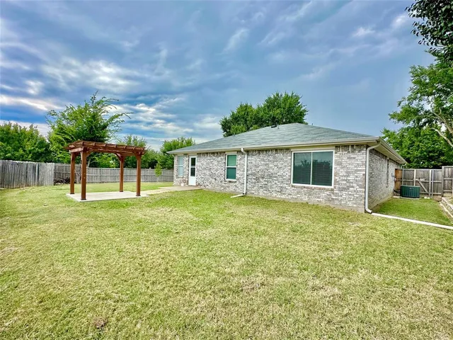 a backyard of a house with table and chairs