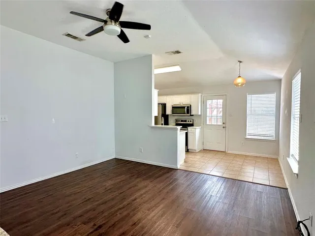 a view of empty room with wooden floor and window