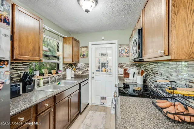 a kitchen with stainless steel appliances granite countertop a stove a sink and a microwave