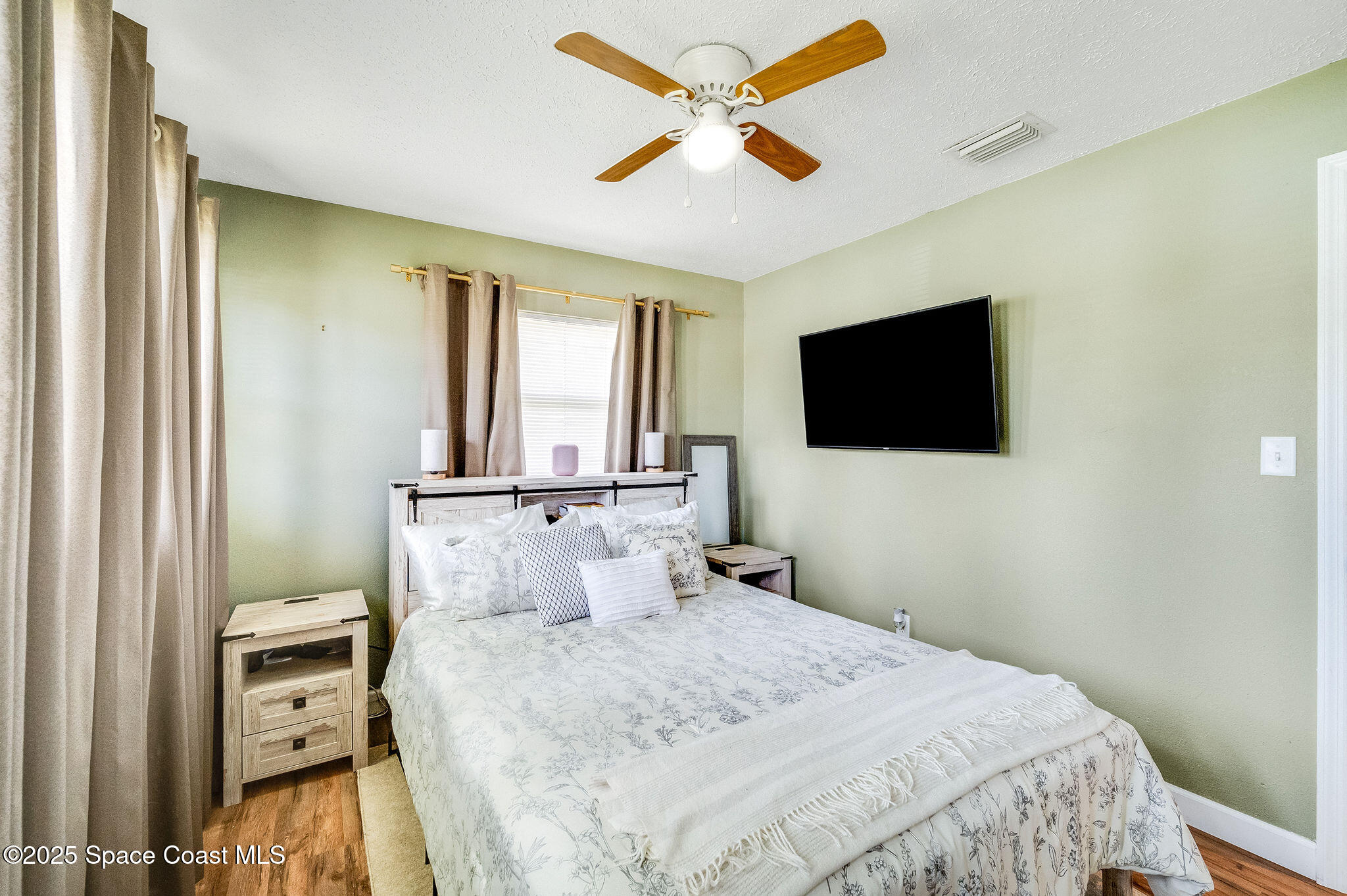 369 Western Avenue Cocoa, FL 32926 - Photo 17 of 38 a bedroom with a bed and a flat tv screen on dresser