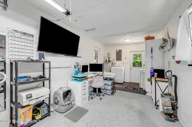 a view of a livingroom with workspace and a flat screen tv