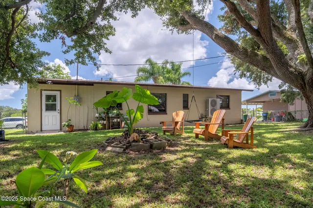 a view of a house with backyard sitting area and garden