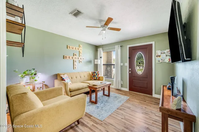 a living room with furniture flat screen tv and a window