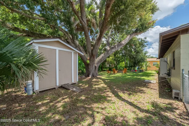 a view of a house with backyard and trees