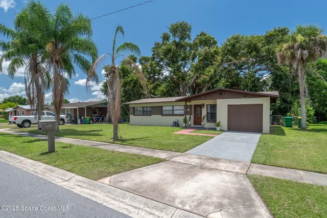 front view of a house with a yard and an trees