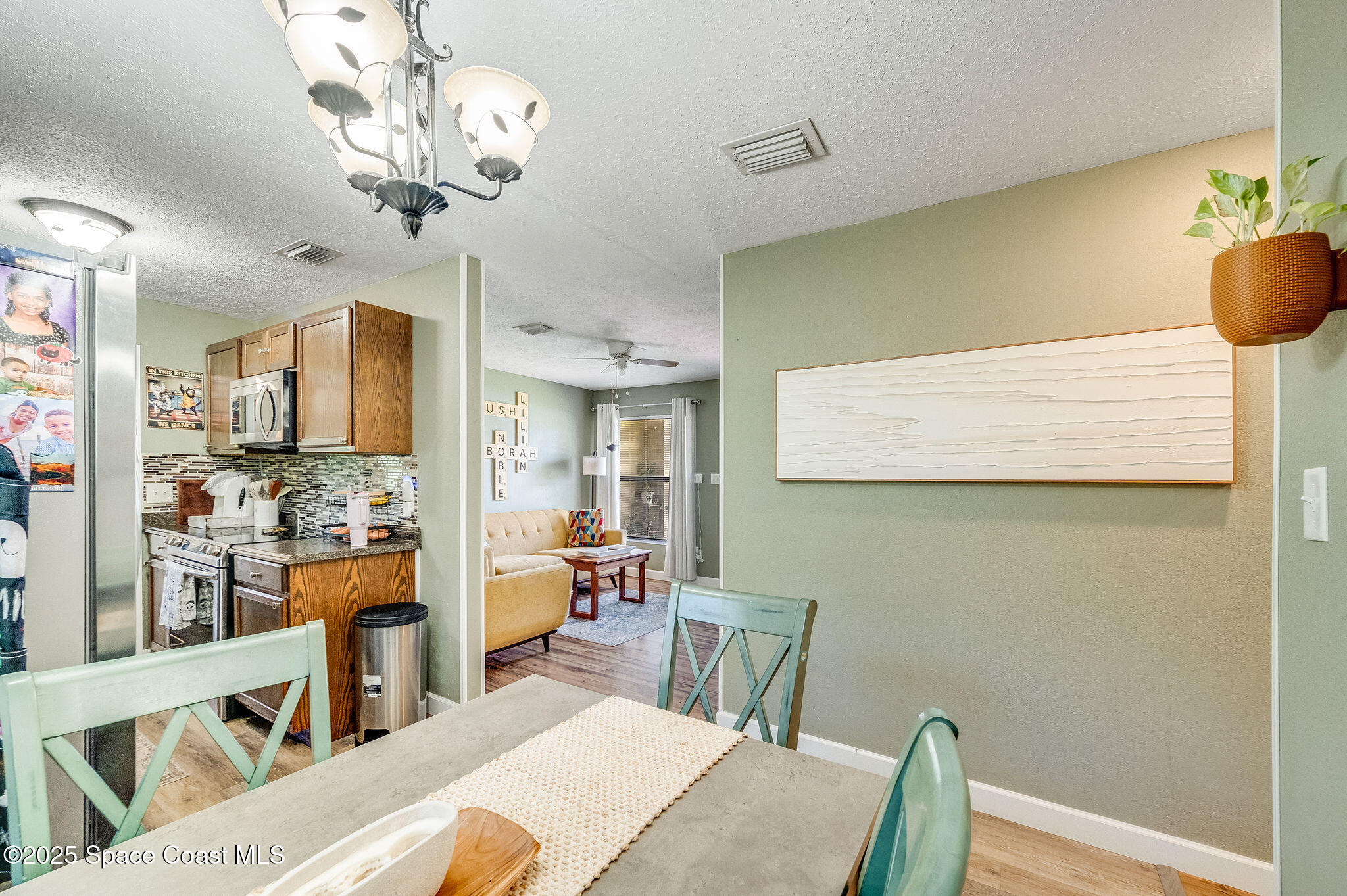 369 Western Avenue Cocoa, FL 32926 - Photo 7 of 38 a view of a dining room with furniture a chandelier and wooden floor