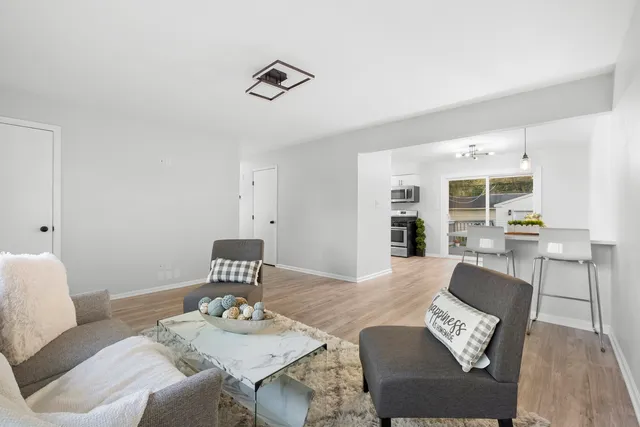 a living room with furniture and view of kitchen