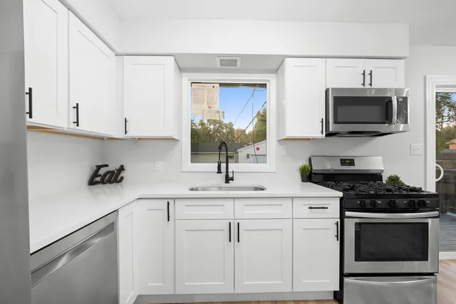 a kitchen with white cabinets and a stove top oven