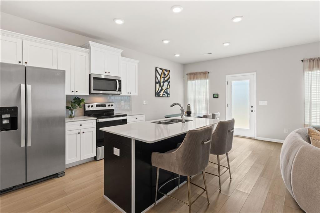2538 Polaris Way Southwest Atlanta, GA 30331 - Photo 6 of 28 a kitchen with stainless steel appliances a sink a stove a refrigerator cabinets and a dining table