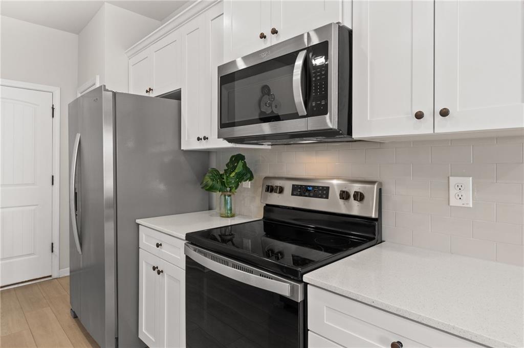 2538 Polaris Way Southwest Atlanta, GA 30331 - Photo 8 of 28 a kitchen with stainless steel appliances white cabinets and a stove a refrigerator with wooden floor