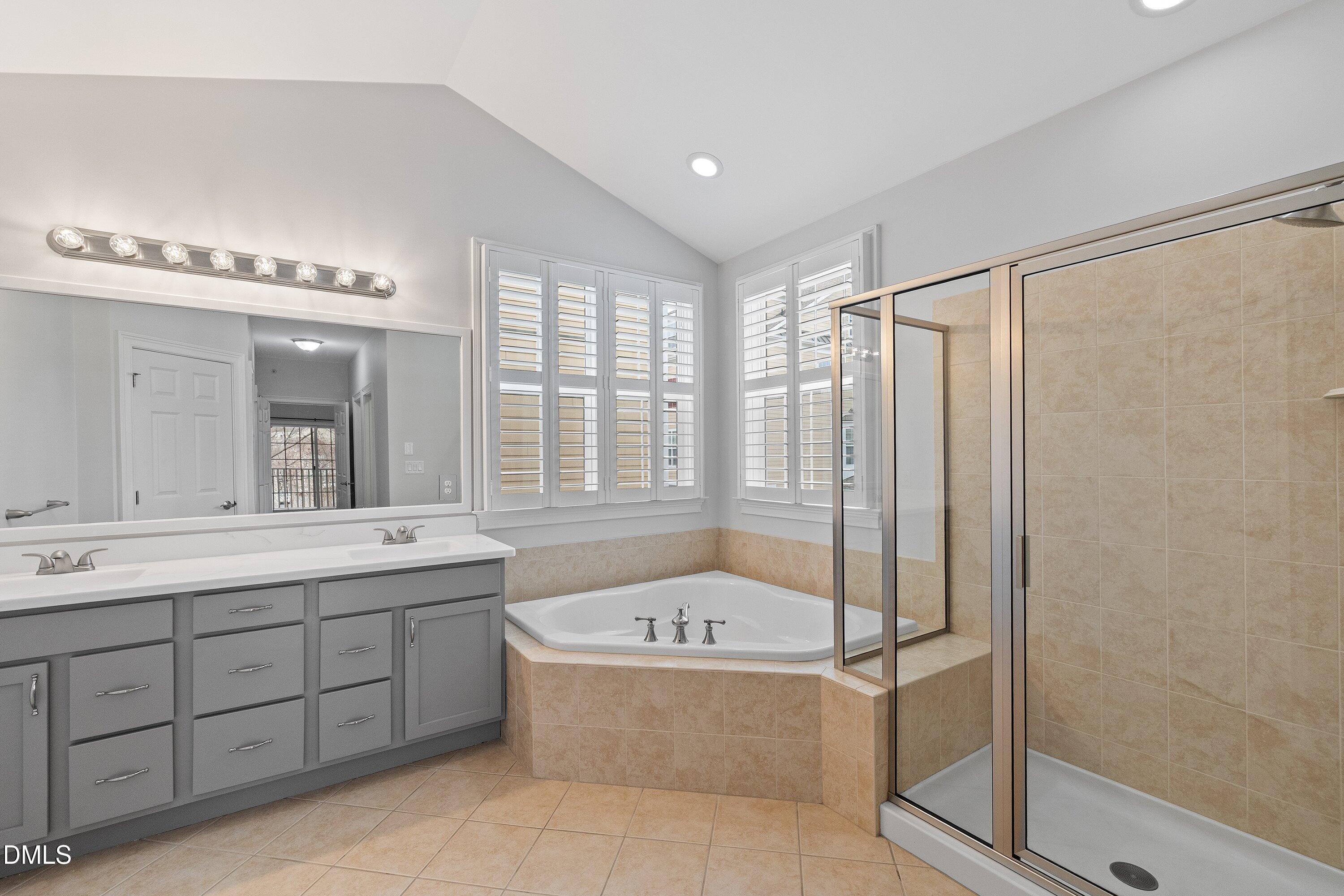 9211 Calabria Drive, Unit 205 Raleigh, NC 27617 - Photo 44 of 55 a bathroom with a tub sink shower and mirror