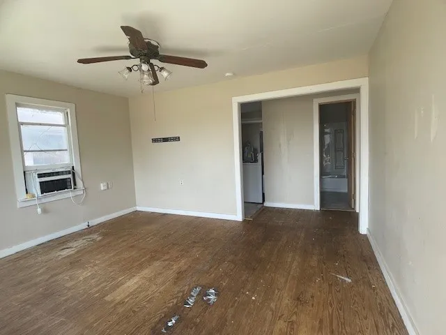 a view of a room with a ceiling fan and hardwood floor