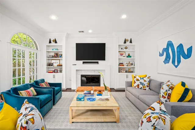 a living room with furniture a flat screen tv and a fireplace