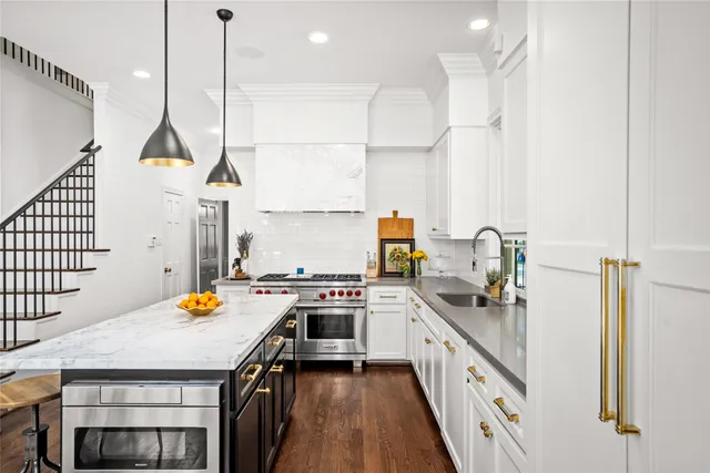 a kitchen with a sink a stove and chairs