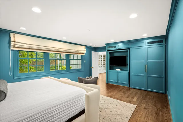 a spacious bedroom with a bed and a television