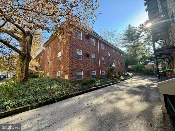 a brick building with tree in front of it