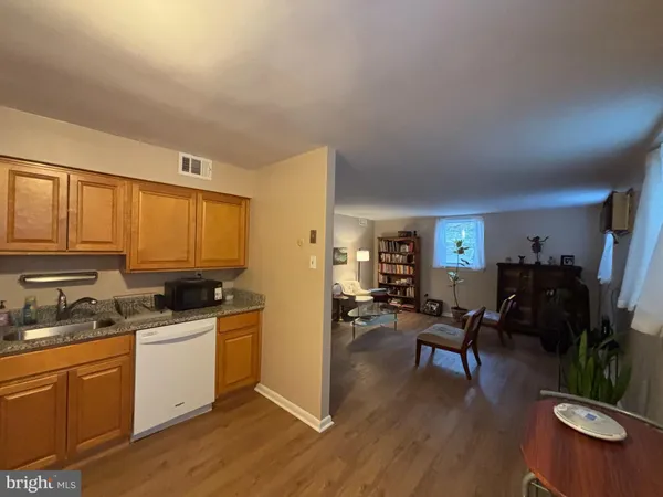 a kitchen with a sink a stove cabinets and wooden floor