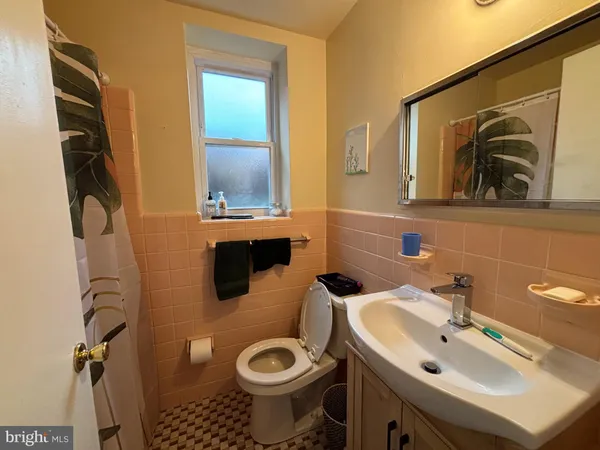 a bathroom with a sink and mirror with toilet