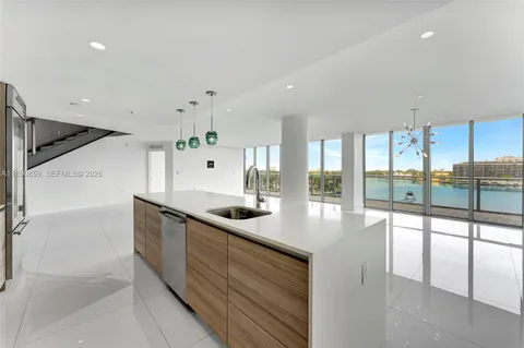 a large white kitchen with a large window