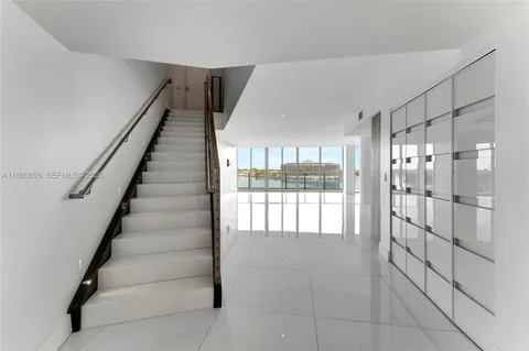 a living room with furniture a flat screen tv and a floor to ceiling window