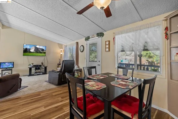 a view of a dining room with furniture a chandelier and wooden floor