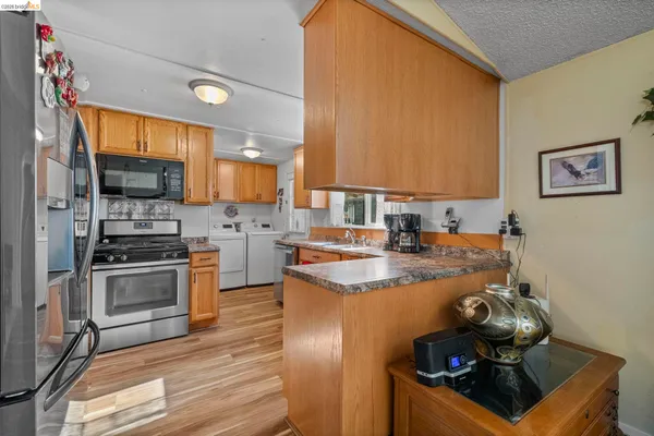 a kitchen with stainless steel appliances granite countertop a stove a sink and a refrigerator