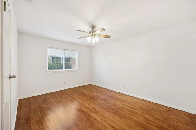 an empty room with a window and a fan