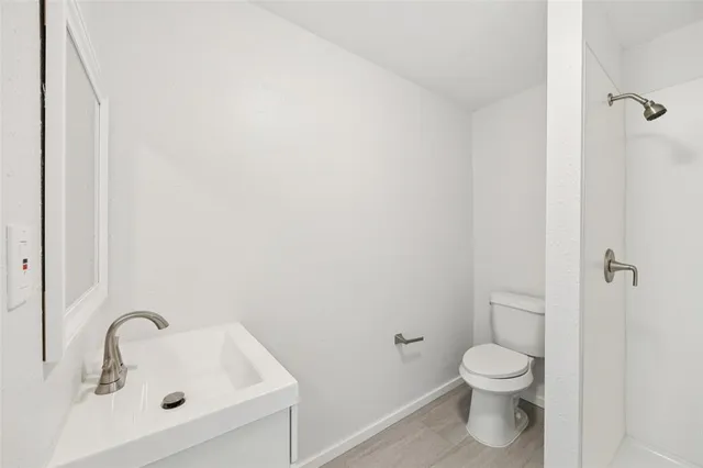 a bathroom with a sink a toilet and shower