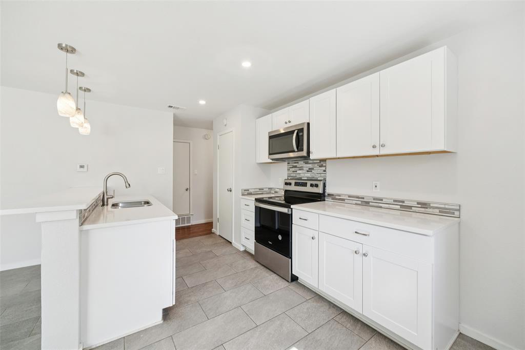 914 Royal Street Forney, TX 75126 - Photo 7 of 28 a kitchen with stainless steel appliances granite countertop a stove top oven a sink dishwasher and white cabinets with wooden floor