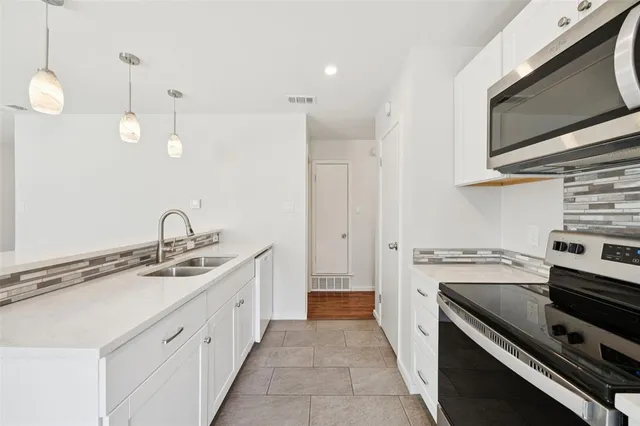 a kitchen with a sink stove and microwave