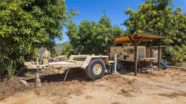 a view of a wooden house with a yard and sitting area