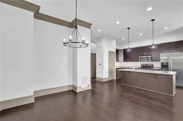a kitchen with stainless steel appliances a refrigerator and wooden floor